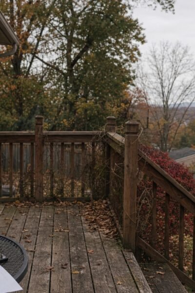 Weathered backyard deck with notebook, tape measure, phone, and a rough site sketch